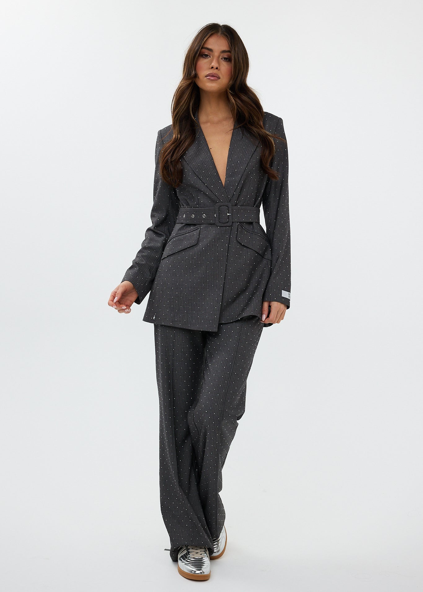 model draagt de ann trousers en de ann blazer van heyb club in grijs met steentjes.