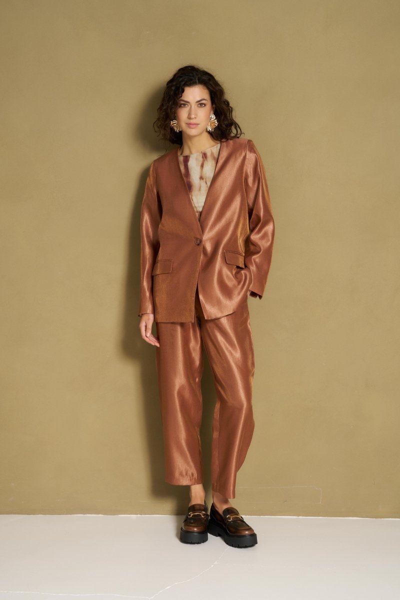 Model in caramel satijnen blazer en bijpassende broek
