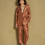 Model in caramel satijnen blazer en bijpassende broek
