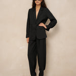 Model in zwart pak: blazer Jadie en pantalon Jax met ingenomen enkels | Jo&Co Club