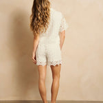 Een model, van achteren gefotografeerd, draagt een gebroken witte tweedelige set | Lofty Manner Denni | Jo&Co Club