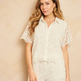 Een model poseert in een tweedelige, gebroken witte set bestaande uit een blouse met korte | Lofty Manner Denni | Jo&Co Club