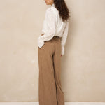 Model van achteren in crème blouse Jett en bruine broek met wijde pijpen | Jo&Co Club