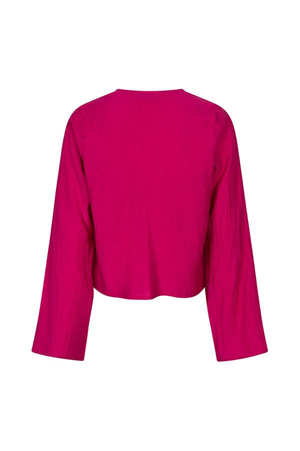 Een model presenteert een levendig fuchsia playsuit tegen een effen beige achtergrond | Lofty Manner Maeve | Jo&Co Club