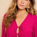 Een model presenteert een levendig fuchsia playsuit tegen een effen beige achtergrond | Lofty Manner Maeve | Jo&Co Club