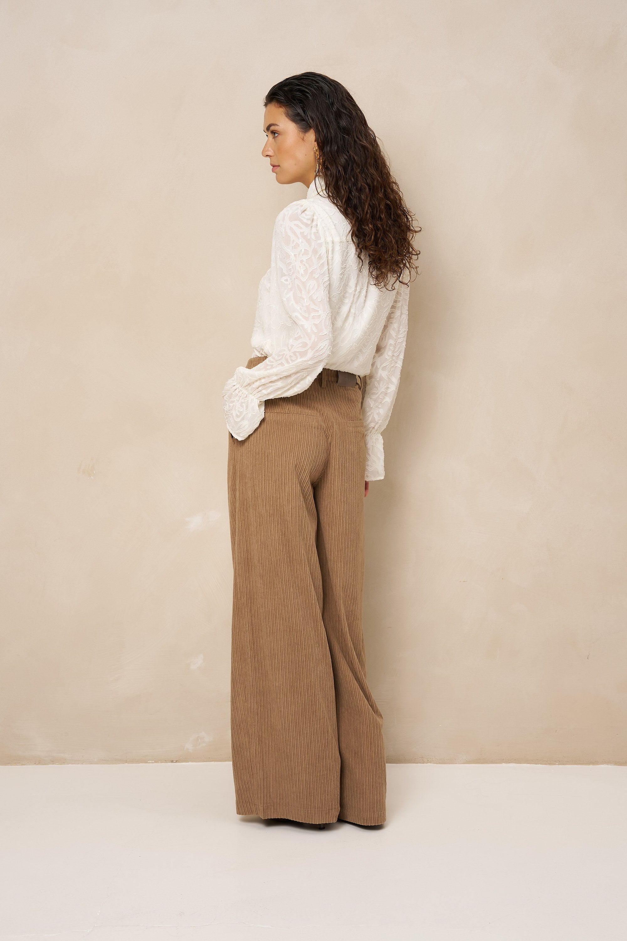 Model van achteren in crème blouse Jett en bruine broek met wijde pijpen | Jo&Co Club