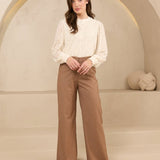 Model draagt trouser shayma met blouse als kantoor outfit.