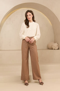 Model draagt trouser shayma met blouse als kantoor outfit.