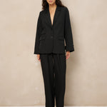 Zwarte pantalon met plooien Lofty Manner Jax – model in zwart pak met open pijpen en blazer Jadie | Jo&Co Club