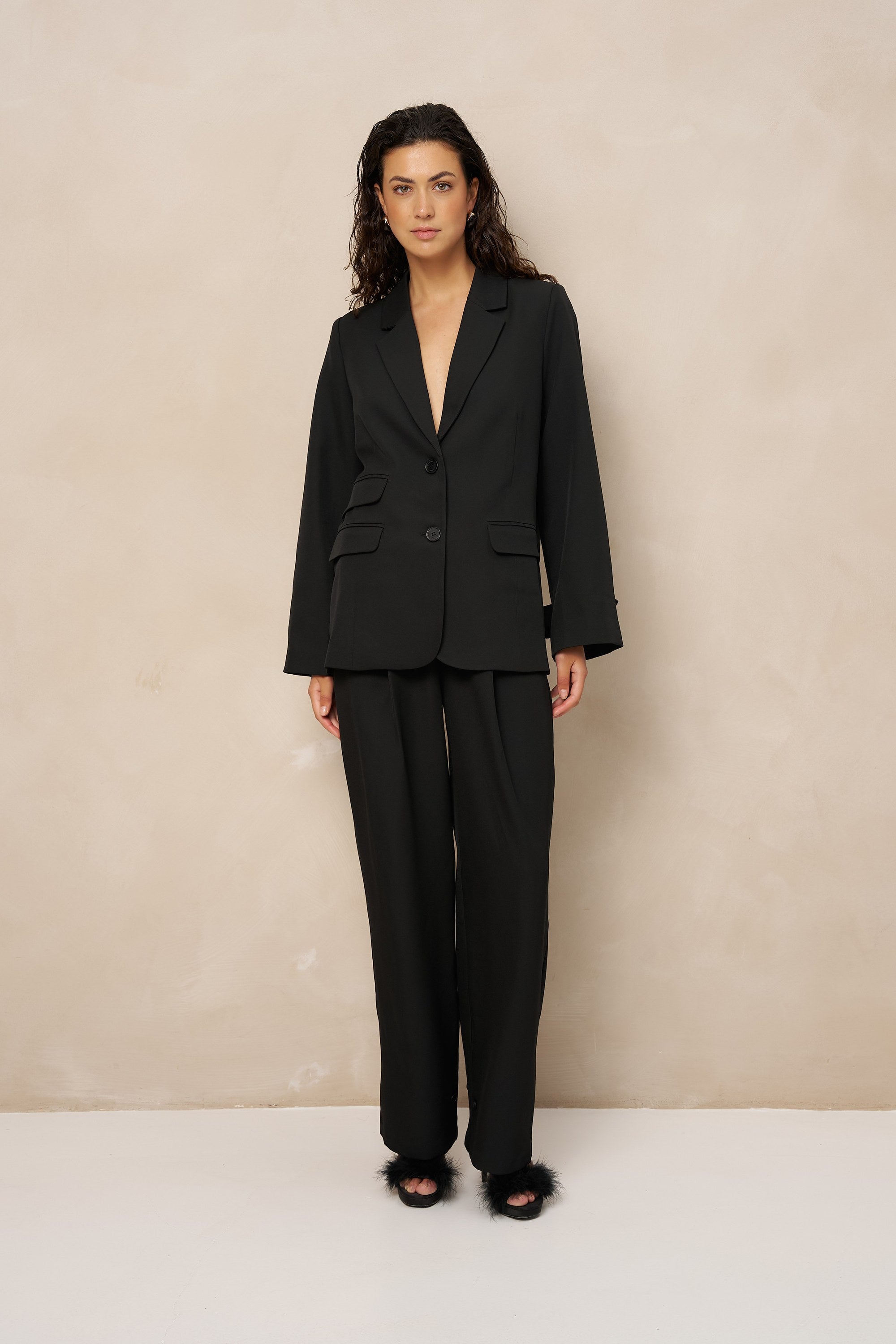 Zwarte pantalon met plooien Lofty Manner Jax – model in zwart pak met open pijpen en blazer Jadie | Jo&Co Club