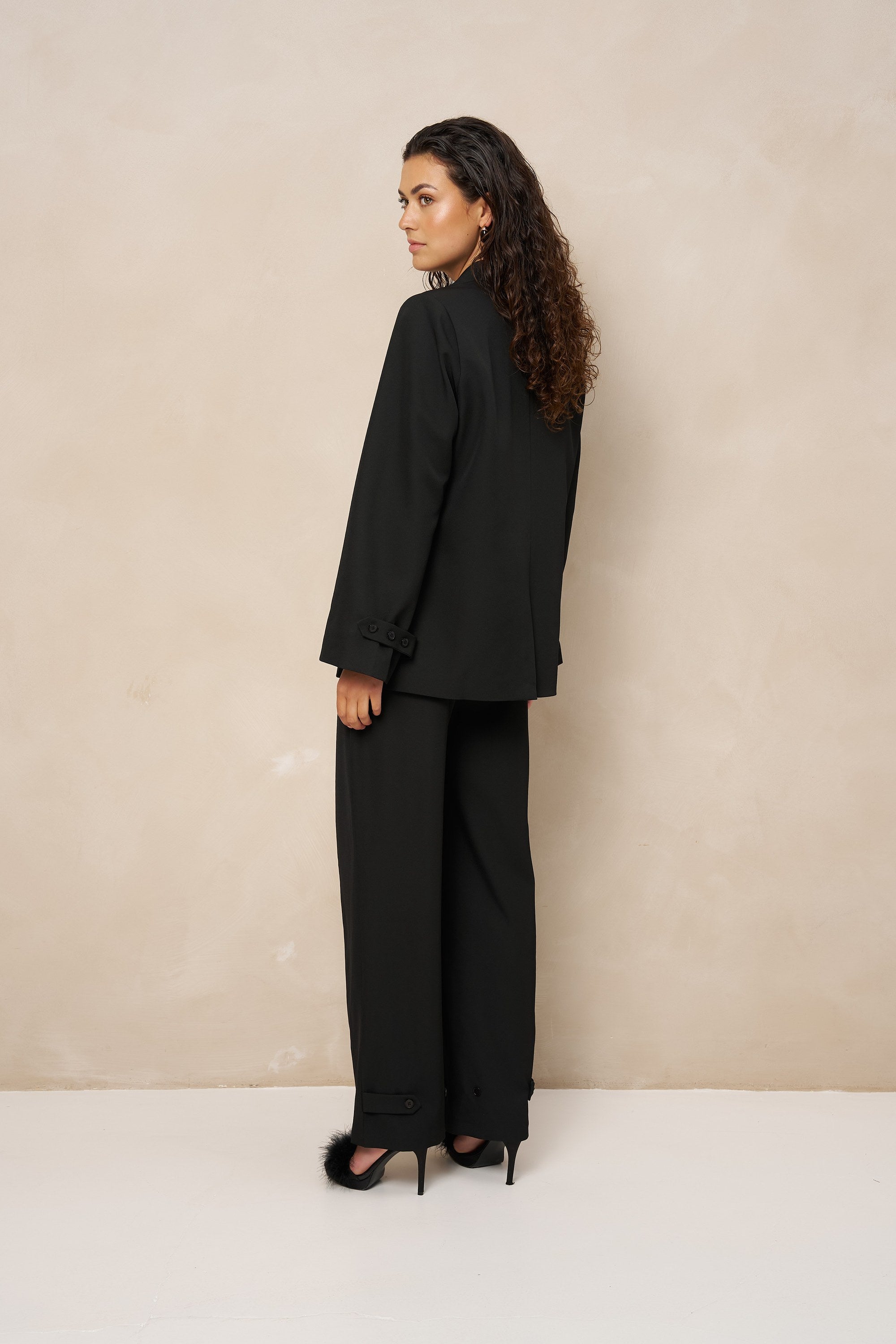 Model van opzij in zwarte pantalon Jax en zwarte blazer Jadie | Jo&Co Club