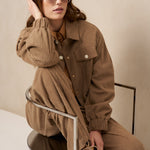 Model zittend in taupe ribcord set Josy en Jaxy met zonnebril | Jo&Co Club