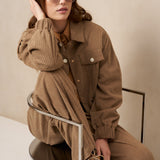 Model zittend in taupe ribcord set Josy en Jaxy met zonnebril | Jo&Co Club