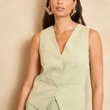 Een productfoto van een mouwloos gilet in een lichte, pistachegroene kleur, gepresenteerd | Lofty Manner Shirin | Jo&Co Club