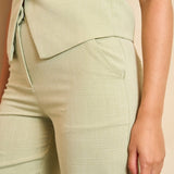 Een productfoto van een mouwloos gilet in een lichte, pistachegroene kleur, gepresenteerd | Lofty Manner Shirin | Jo&Co Club