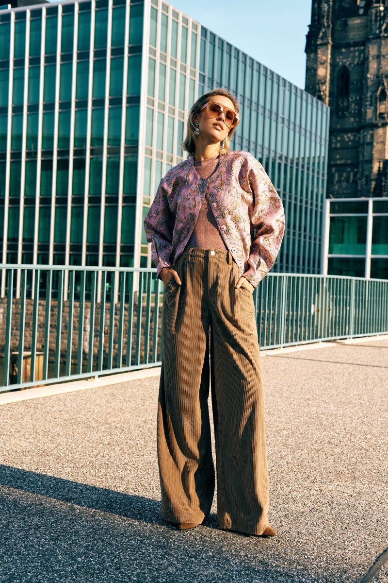 Campagnefoto: model in roze jacquard bomberjack Jules met bruine wijde pantalon in de stad | Jo&Co Club