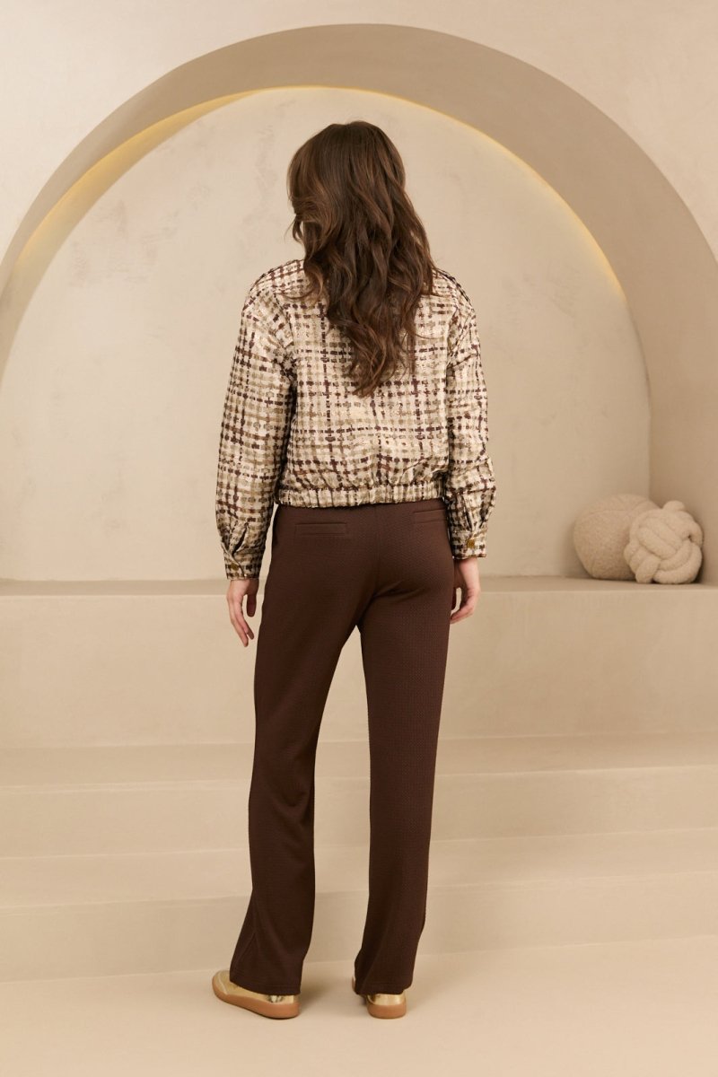 Achteraanzicht van het lofty manner noor jacket, gedragen door model met bruine broek.