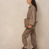 Model van opzij in taupe kunstleren jack Jillie met taupe clutch | Jo&Co Club