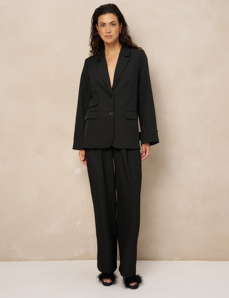Zwarte pantalon met plooien Lofty Manner Jax – model in zwart pak met open pijpen en blazer Jadie | Jo&Co Club