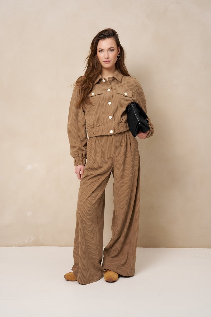 Model in taupe ribcord set: broek Josy en jasje Jaxy met zwarte tas | Jo&Co Club