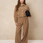 Model in taupe ribcord set: broek Josy en jasje Jaxy met zwarte tas | Jo&Co Club