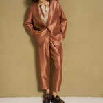 Model in caramel satijnen broek en bijpassende blazer
