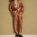 Model in caramel satijnen broek en bijpassende blazer
