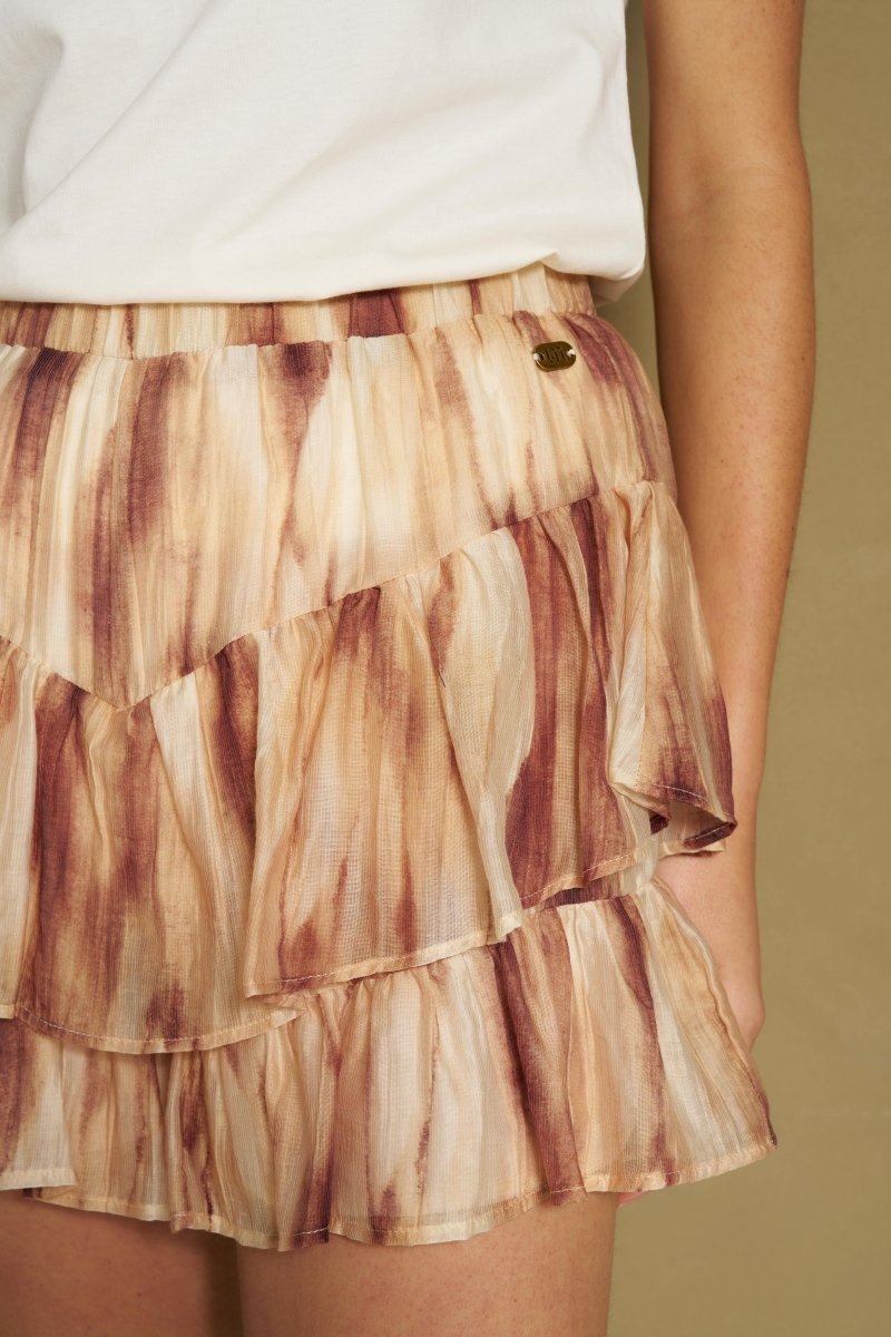 Detail van bruine tie-dye ruffle rok met dubbele volantlaag