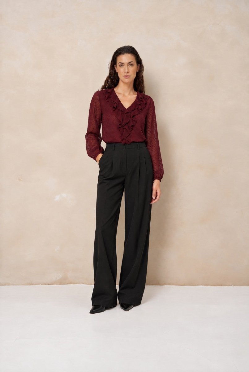 Model in ruche blouse Lofty Manner Kio met wijde zwarte broek, voorkant | Jo&Co Club