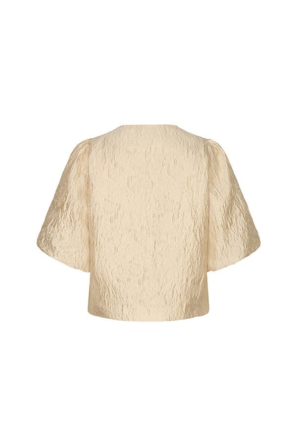 De foto toont de achterkant van een crèmekleurige blouse op een witte achtergrond | Lofty Manner Gianna | Jo&Co Club