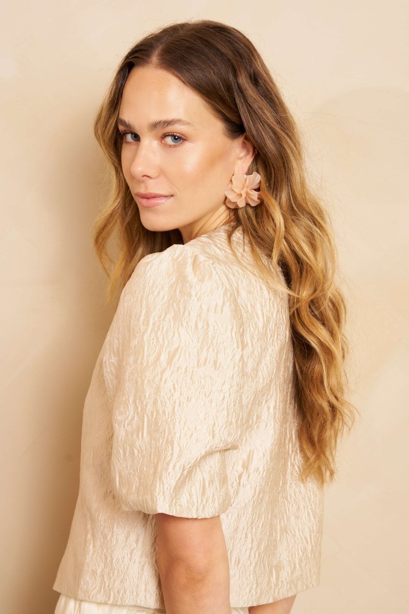 Een model, van de achterkant gefotografeerd, kijkt over haar linkerschouder naar de camera | Lofty Manner Gianna | Jo&Co Club