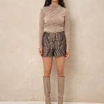 Model in taupe top Jimmi met short met slangenprint en taupe laarzen | Jo&Co Club