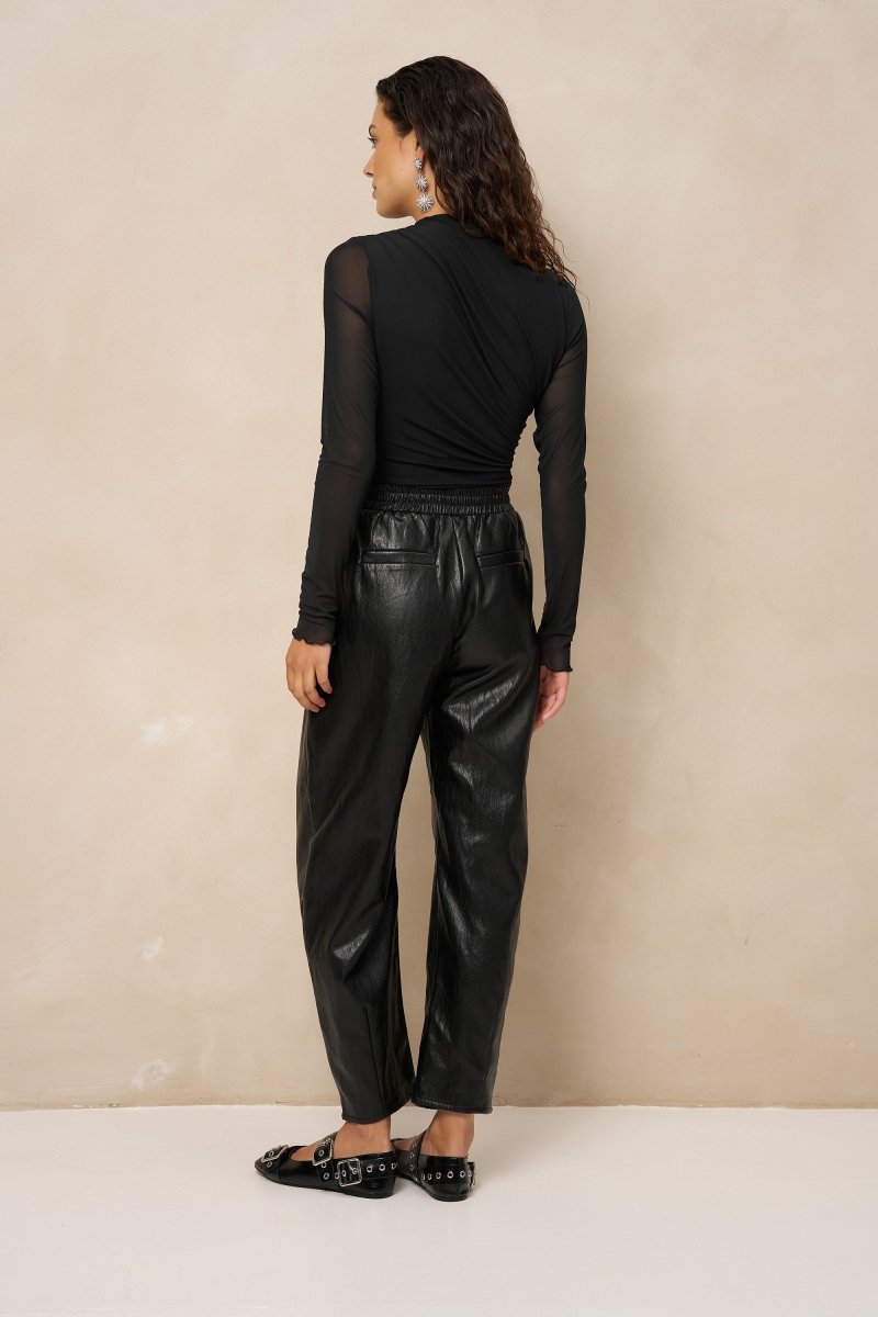 Model van achteren in zwarte mesh top Jolien met transparante mouwen | Jo&Co Club