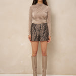 Model in taupe top Jimmi met short met slangenprint en taupe laarzen | Jo&Co Club