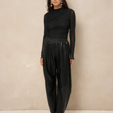 Model in zwarte gedrapeerde mesh top Jolien, total black met glanzende broek | Jo&Co Club