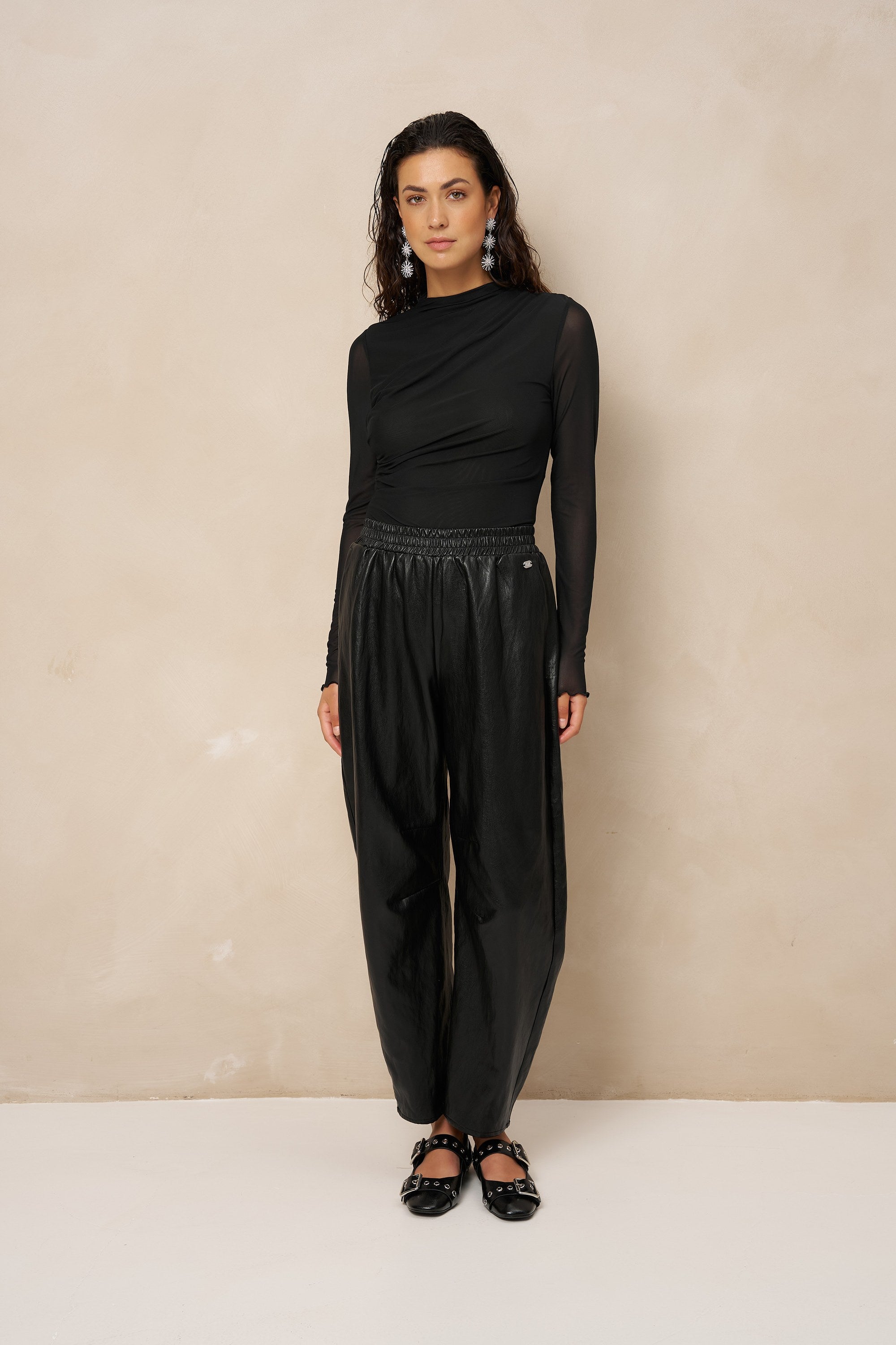 Model in zwarte gedrapeerde mesh top Jolien, total black met glanzende broek | Jo&Co Club
