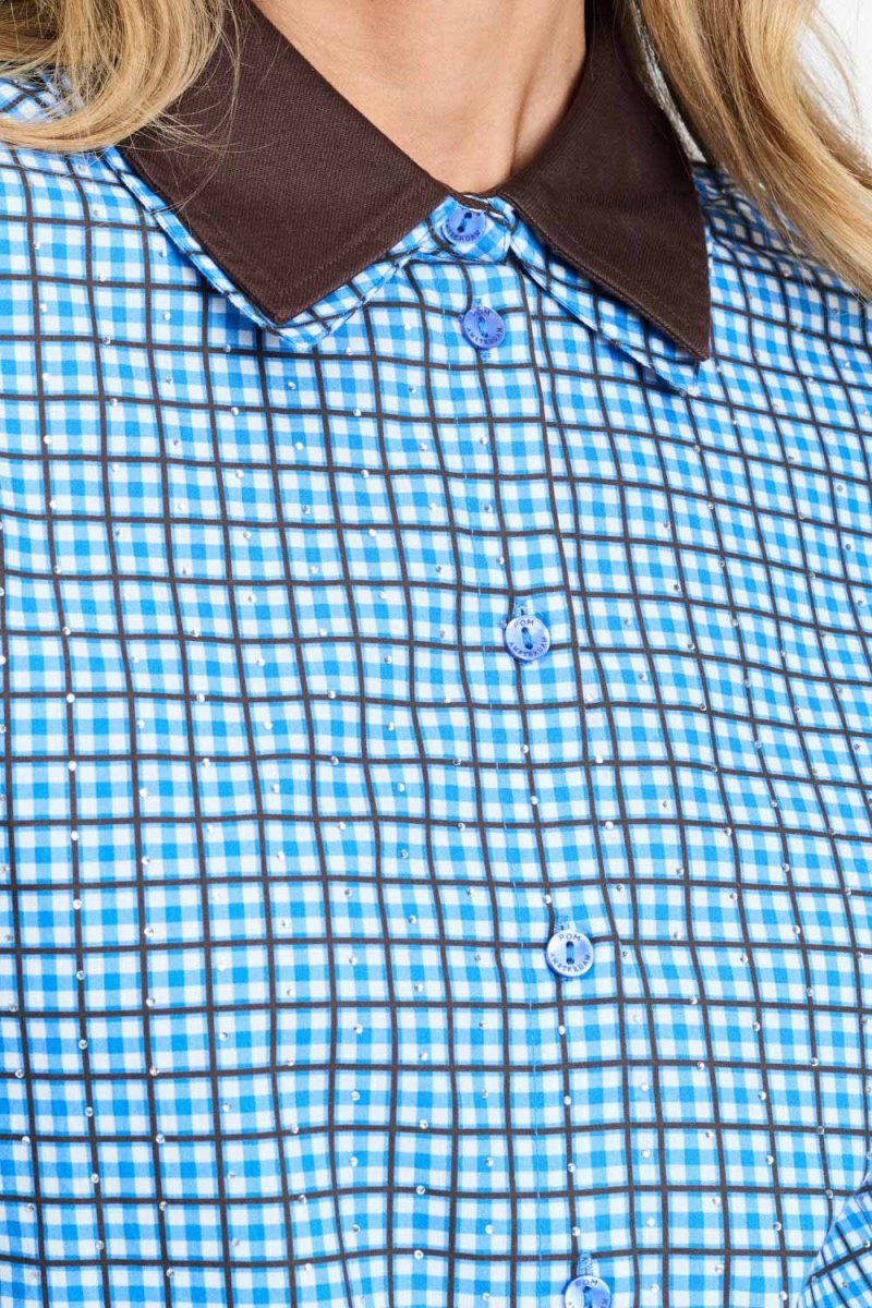 Detailfoto van de bruine kraag en de knopen van de blauw geruite blouse.