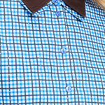 Detailfoto van de bruine kraag en de knopen van de blauw geruite blouse.