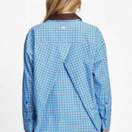 Achterkant van de blauw geruite blouse met verlaagde schouders en langer achterpand.