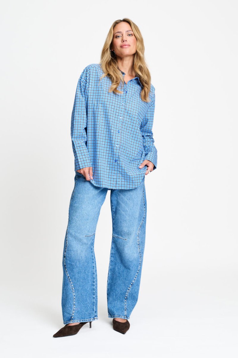 Volledige look met de geruite blouse los gedragen over een wijde jeans.