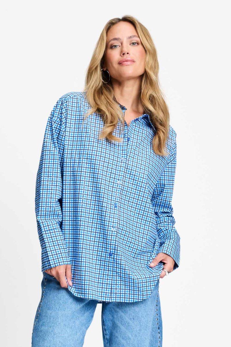Blauw geruite blouse met chocoladebruine kraag, van dichtbij op de voorkant gefotografeerd.