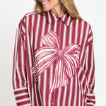 Gestreepte blouse met overhemdkraag en roze strikprint, van dichtbij op de voorkant gefotografeerd.