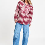 Volledige look met de gestreepte blouse los gedragen op een lichtblauwe wijde jeans.