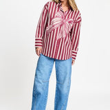 Volledige look met de gestreepte blouse los gedragen op een lichtblauwe wijde jeans.