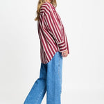 Zijaanzicht van de gestreepte blouse met ruime pasvorm en brede manchetten.