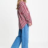 Zijaanzicht van de gestreepte blouse met ruime pasvorm en brede manchetten.