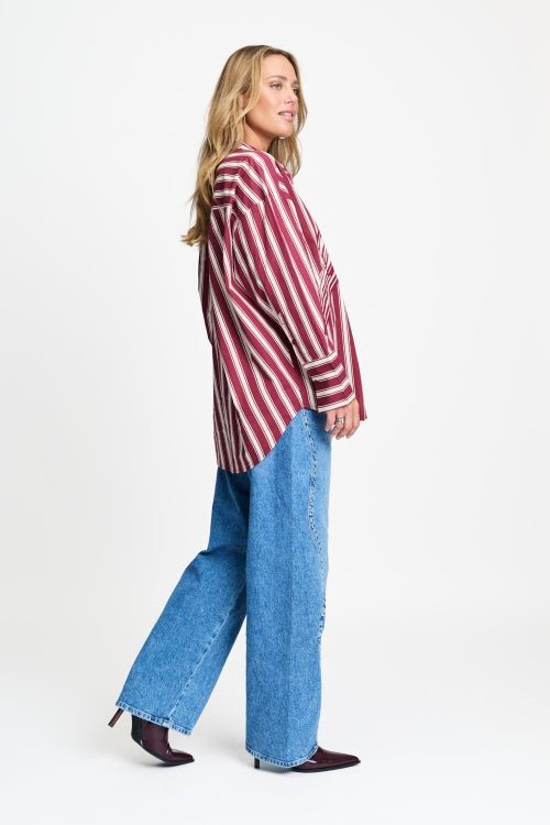 Zijaanzicht van de gestreepte blouse met ruime pasvorm en brede manchetten.