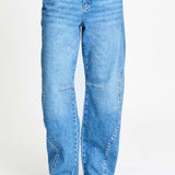 De brede pijpen van de jeans van dichtbij, gedragen op een hak.