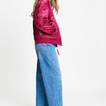 Volledige look met de bomberjas op een wijde lichtblauwe jeans en donkere laarzen.