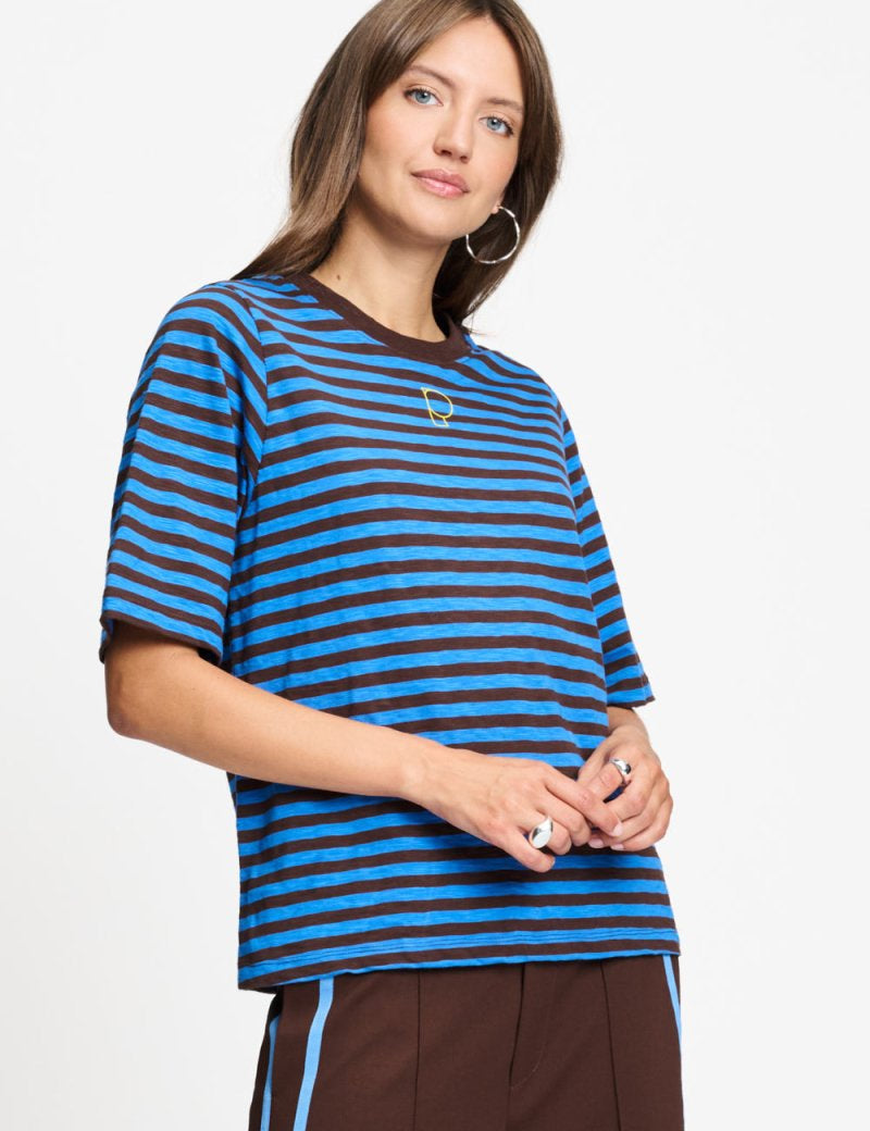 Model draagt het blauw met bruin gestreepte t-shirt Tyra van POM Amsterdam.